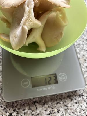 Mushrooms on a set of kitchen scales. 123g