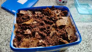 Ice cream tub filled with wet coffee grounds and cardboard